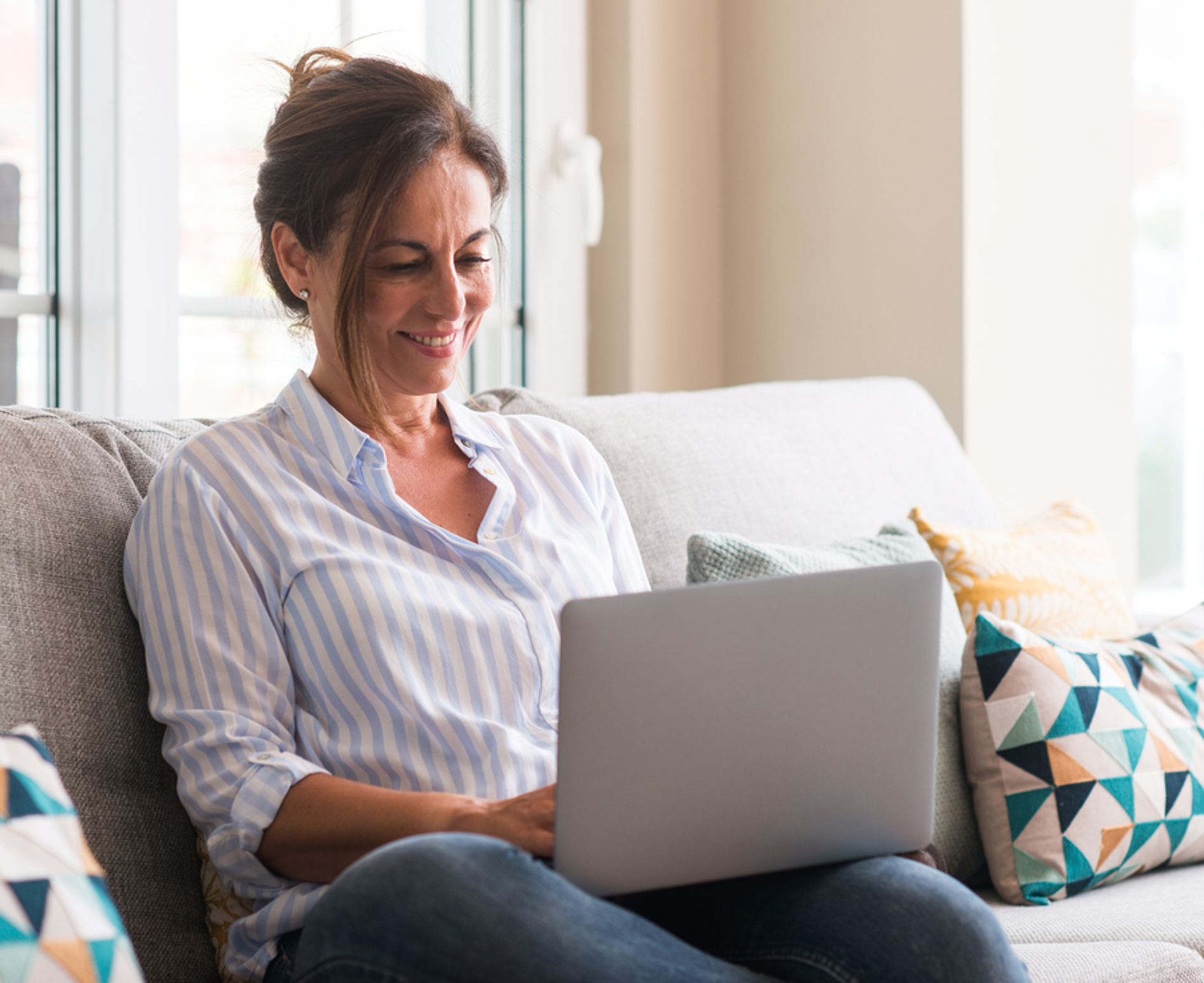 Woman sitting on a couch with her laptop computer.